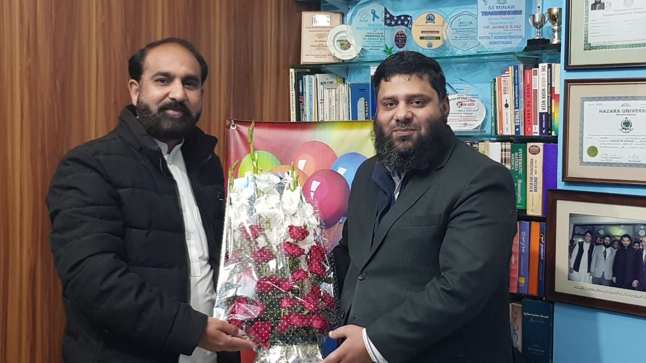 Dr. Ahmed Ejaz receiving a bouquet in his office