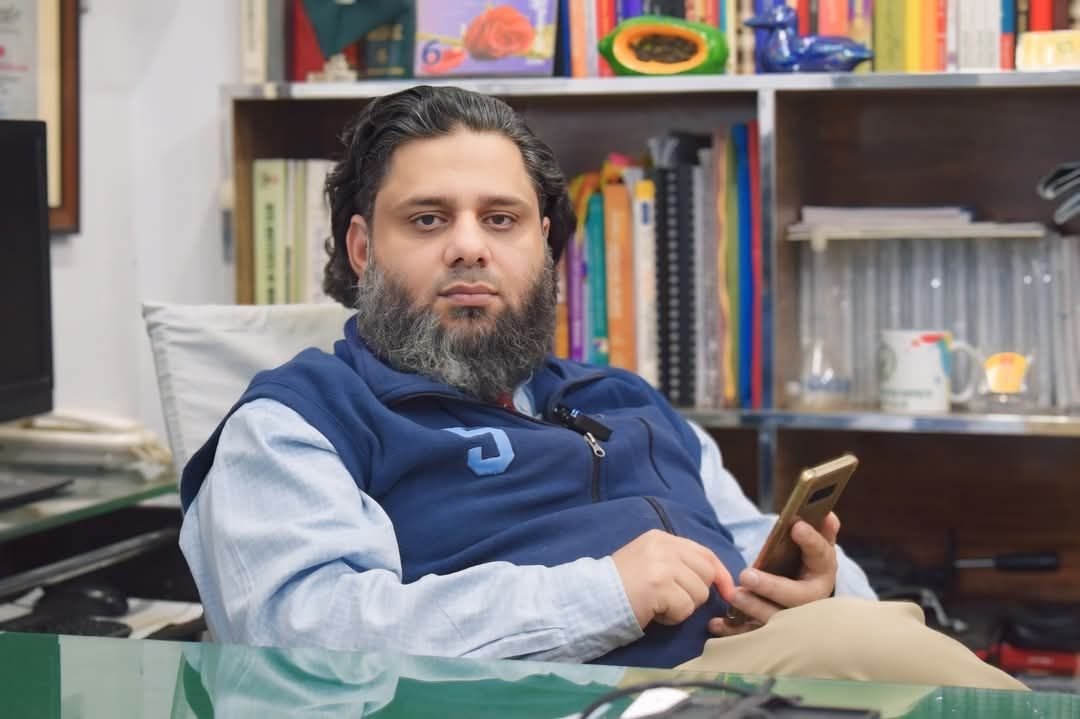 Dr. Ahmed Ejaz seated in his office in front of a bookshelf