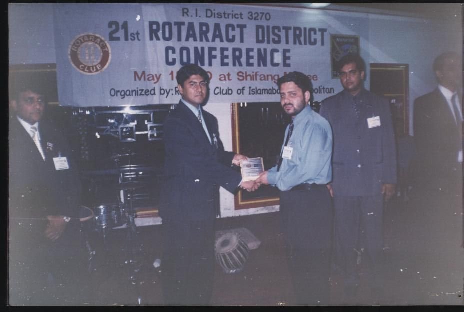 A young Ahmed Ejaz receiving a plaque at the 21st Rotaract District Conference