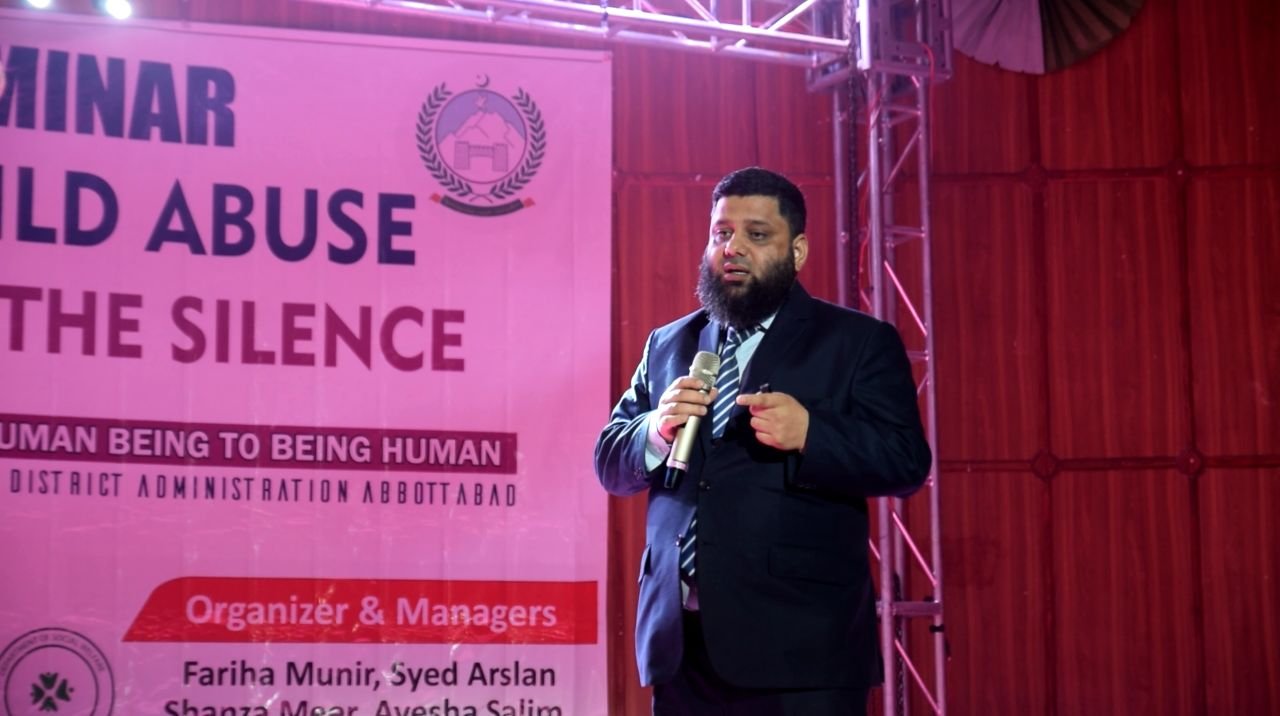 Dr. Ahmed Ejaz speaking on stage at the Shatter the Silence seminar on child abuse