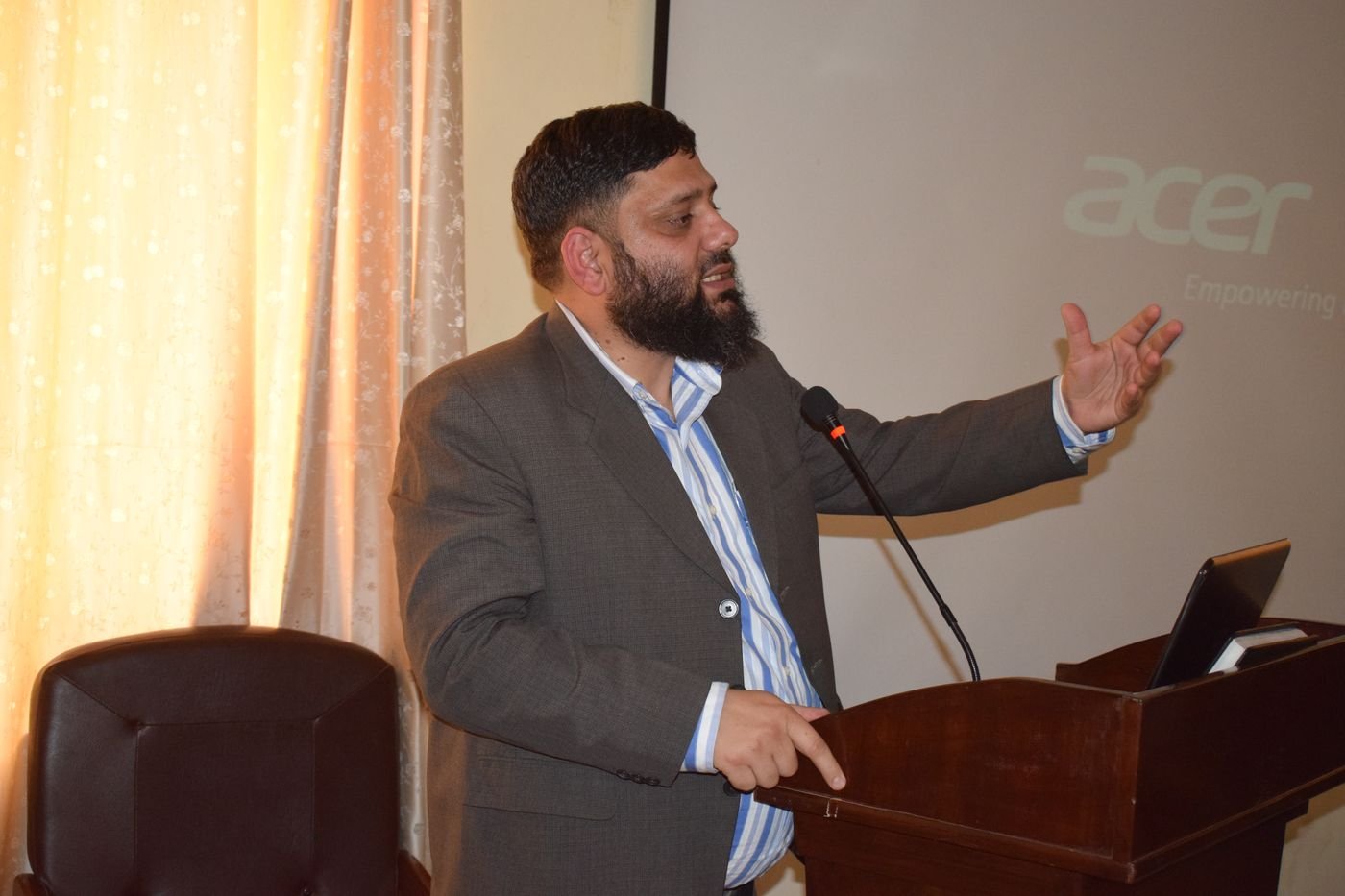 Dr. Ahmed Ejaz presenting at a podium