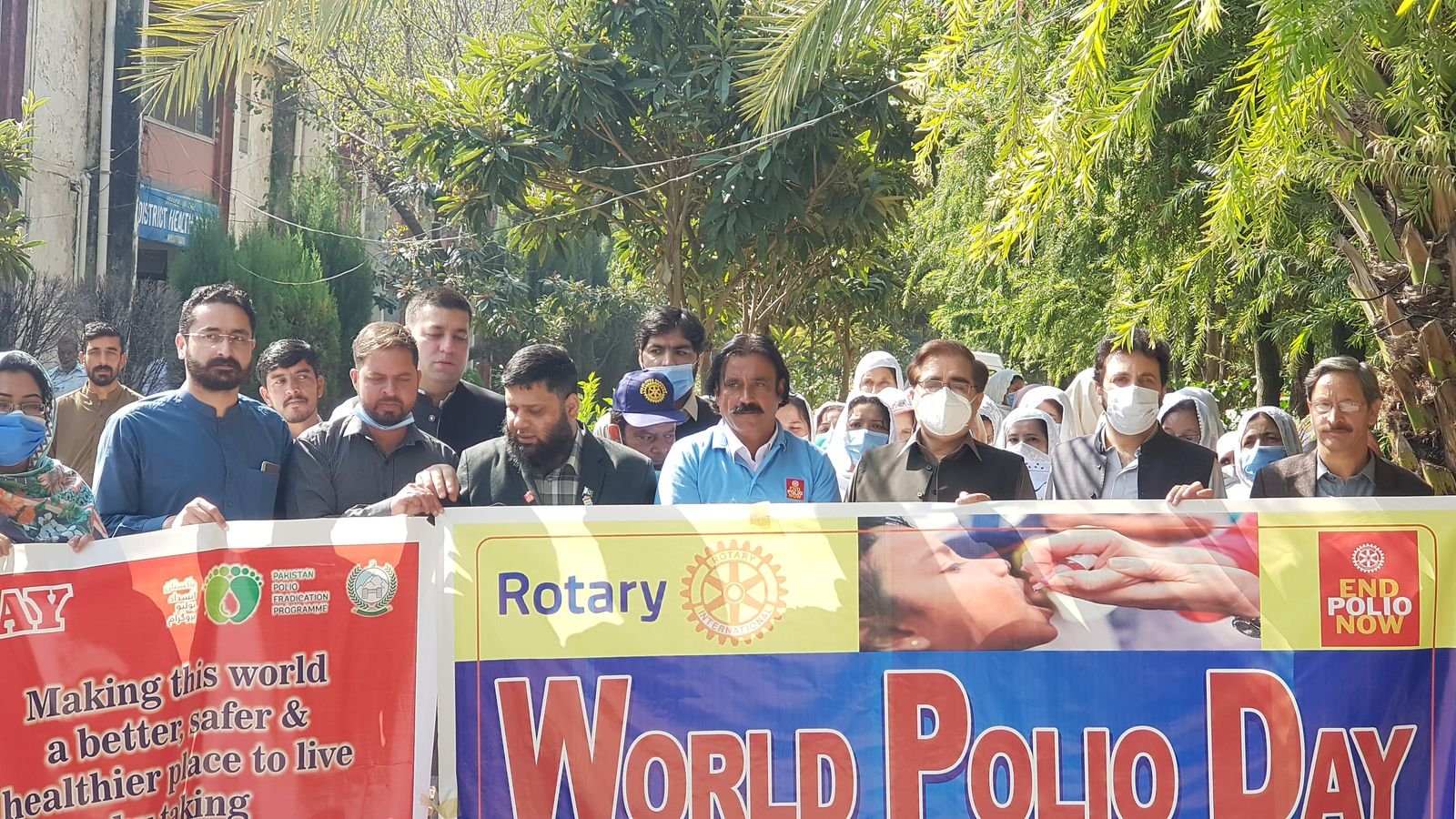 Dr. Ahmed Ejaz leading a World Polio Day walk behind a Rotary End Polio Now banner